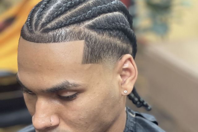 Man with sharp cornrow braids and a lineup