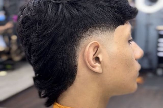 Man with a modern curly mullet and taper fade
